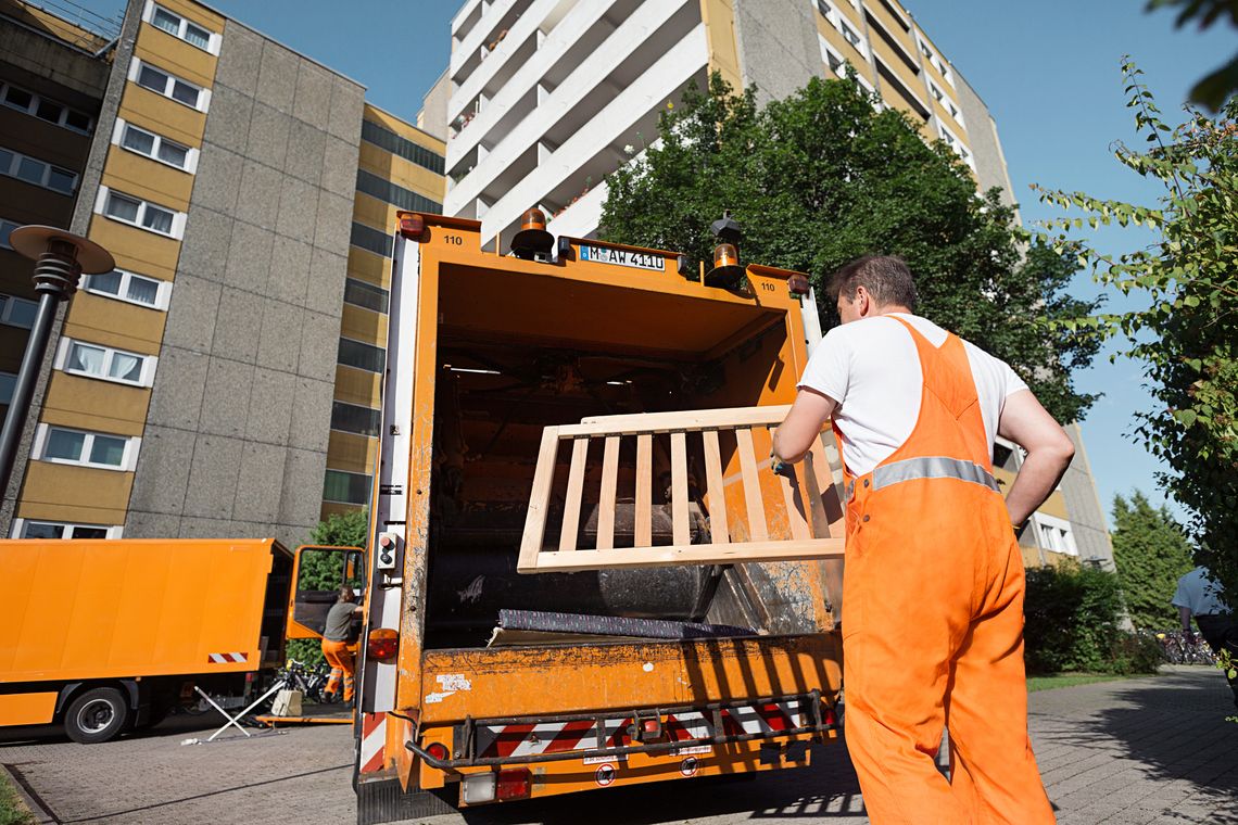 Ein Mitarbeiter lädt Sperrmüll in das Fahrzeug